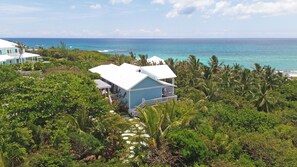 Une propriété située sur la côte, dotée d’une grande maison, d’une végétation luxuriante et offrant une vue sur l’océan.
