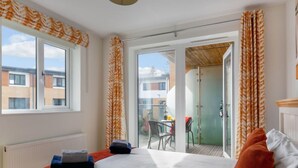 A hotel room with a bed, a radiator, a window, and a view of the outside. - Stones Throw by Interhome (Charlestown)