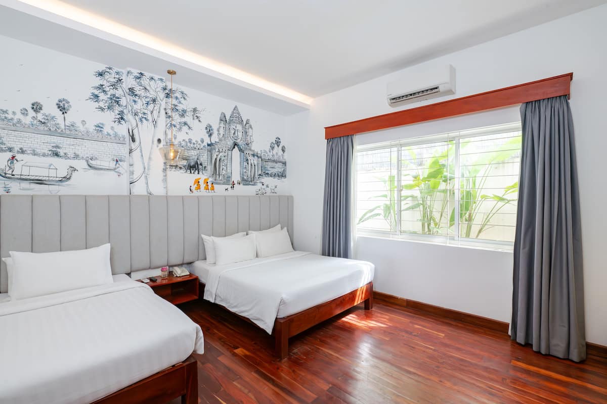 Une chambre d’hôtel avec deux lits, une grande fresque murale, une fenêtre avec des rideaux et un plancher en bois.