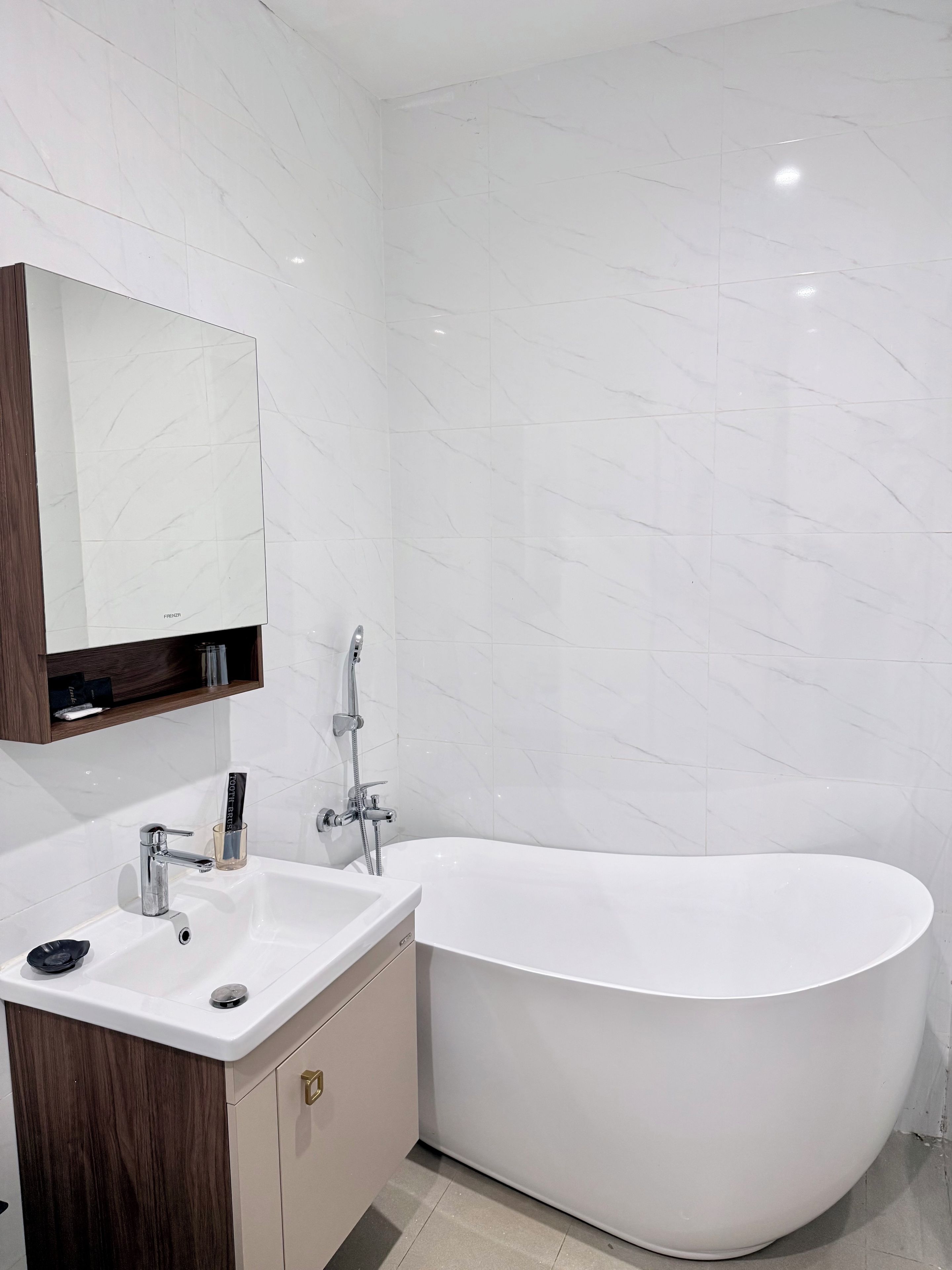 Une salle de bain moderne avec une baignoire sur pieds, un lavabo et un miroir.