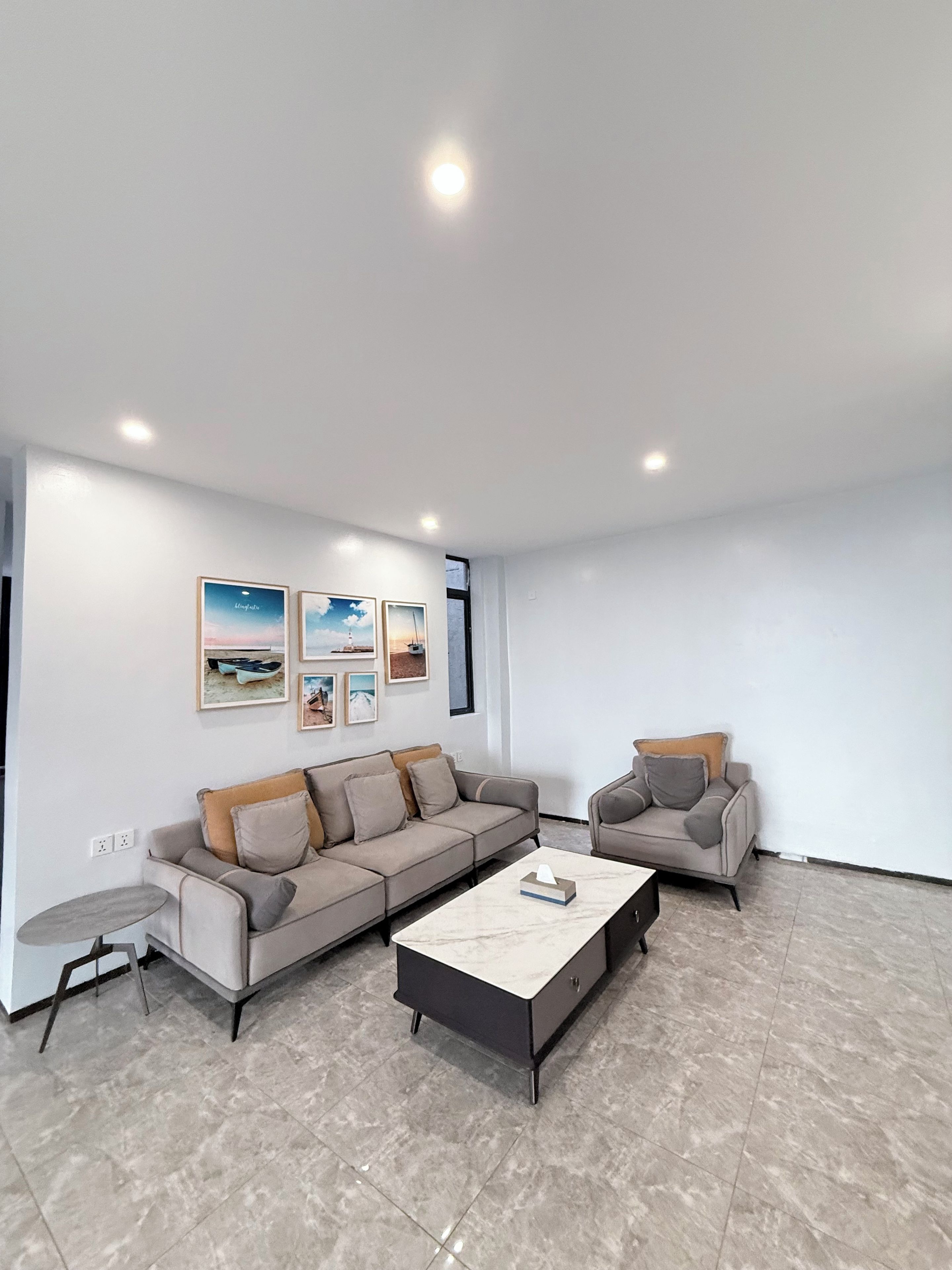 A modern living room with a sectional sofa, a smaller armchair, a coffee table, and a small side table.
