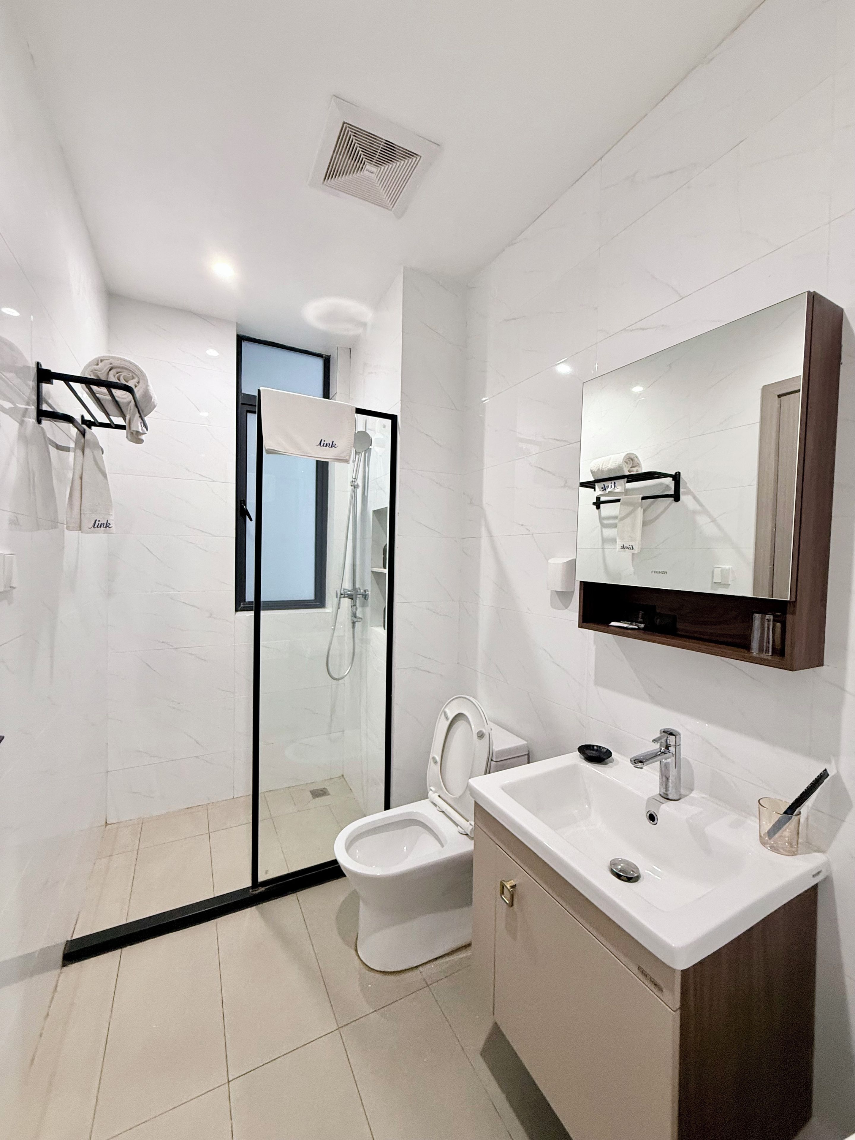 A modern bathroom with a toilet, sink, and shower area.
