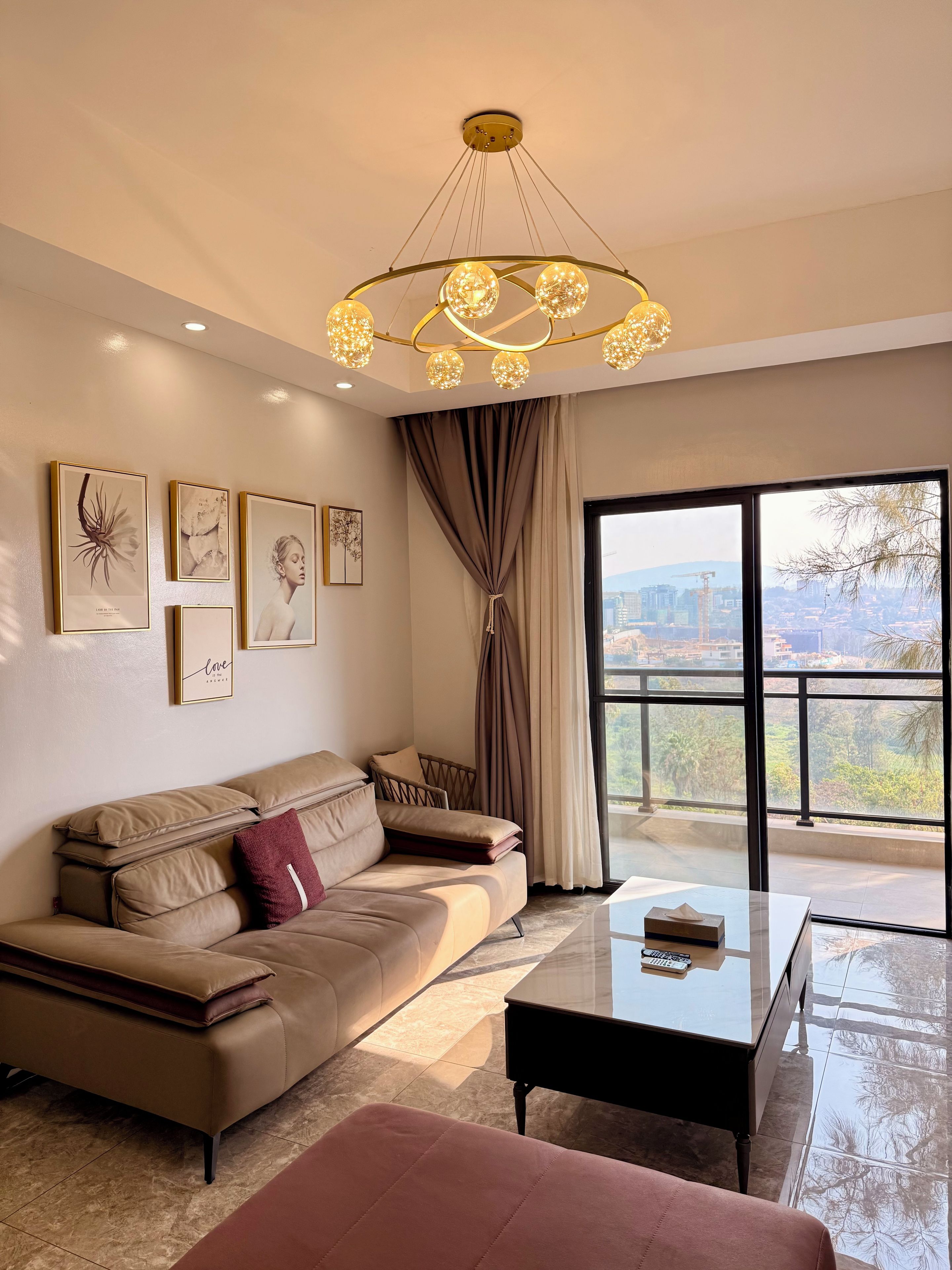 A modern living room with a sofa, a coffee table, and a large window with a view of the cityscape.