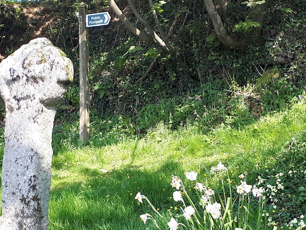 Ein Steinsockel mit einem Hinweisschild für einen öffentlichen Fußweg.