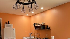 A compact kitchen with a microwave, sink, and dining area.