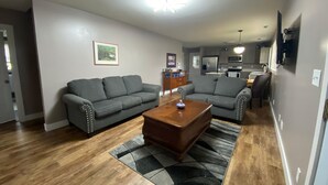 A living room with two grey sofas, a wooden coffee table, and a patterned rug.