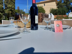 A table set for a meal with wine glasses, a bottle of wine, and a menu card. - Magnificent wooded villa, ideally located close to the beach. (L'Escala)