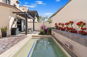 A swimming pool with a stone patio, a covered seating area, and a garden with various plants and flowers. - Copala Luxury Villa Oceanview, Private Pool (Cabo San Lucas)
