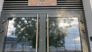 A building entrance with a sign reading "LE CASTEL" and the number "11" above.