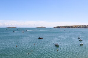 A coastal scene with boats on the water, a clear sky, and distant hills. - Watlands (Pwllheli)