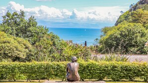 A sculpture in a garden with a view of the ocean and hills. - Watlands (Pwllheli)