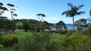 A golf course with a view of the sea and houses in the background. - Tee to Sea - 3BR home with golf & ocean views (Mollymook)