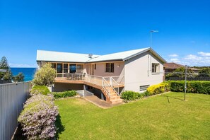 A two-story house with a balcony, a satellite dish, and a view of the ocean. - Magnificent Outlook (Mollymook Beach)