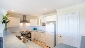Enjoy cooking in this well-equipped kitchen with a stainless steel stove, oven, and refrigerator.