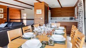Un comedor con una mesa de madera dispuesta para una comida, rodeado de sillas.