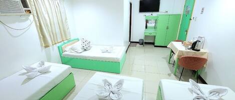 Una habitación de hotel con dos camas, un escritorio, una silla, un televisor y un armario verde.