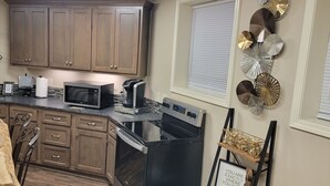 A modern kitchen with wooden cabinets, a microwave, a coffee maker, and a dishwasher. - Apartment at the base of the Blue Ridge Mountains (Lenoir)