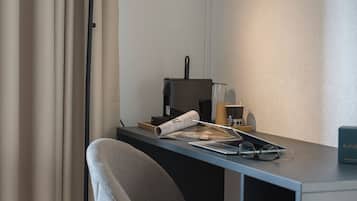 Un espace de bureau moderne comprenant un bureau, une chaise, une lampe et un téléviseur à écran plat.