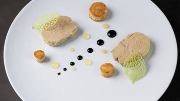 A white plate with a dessert consisting of two round items, small round items, and decorative elements.