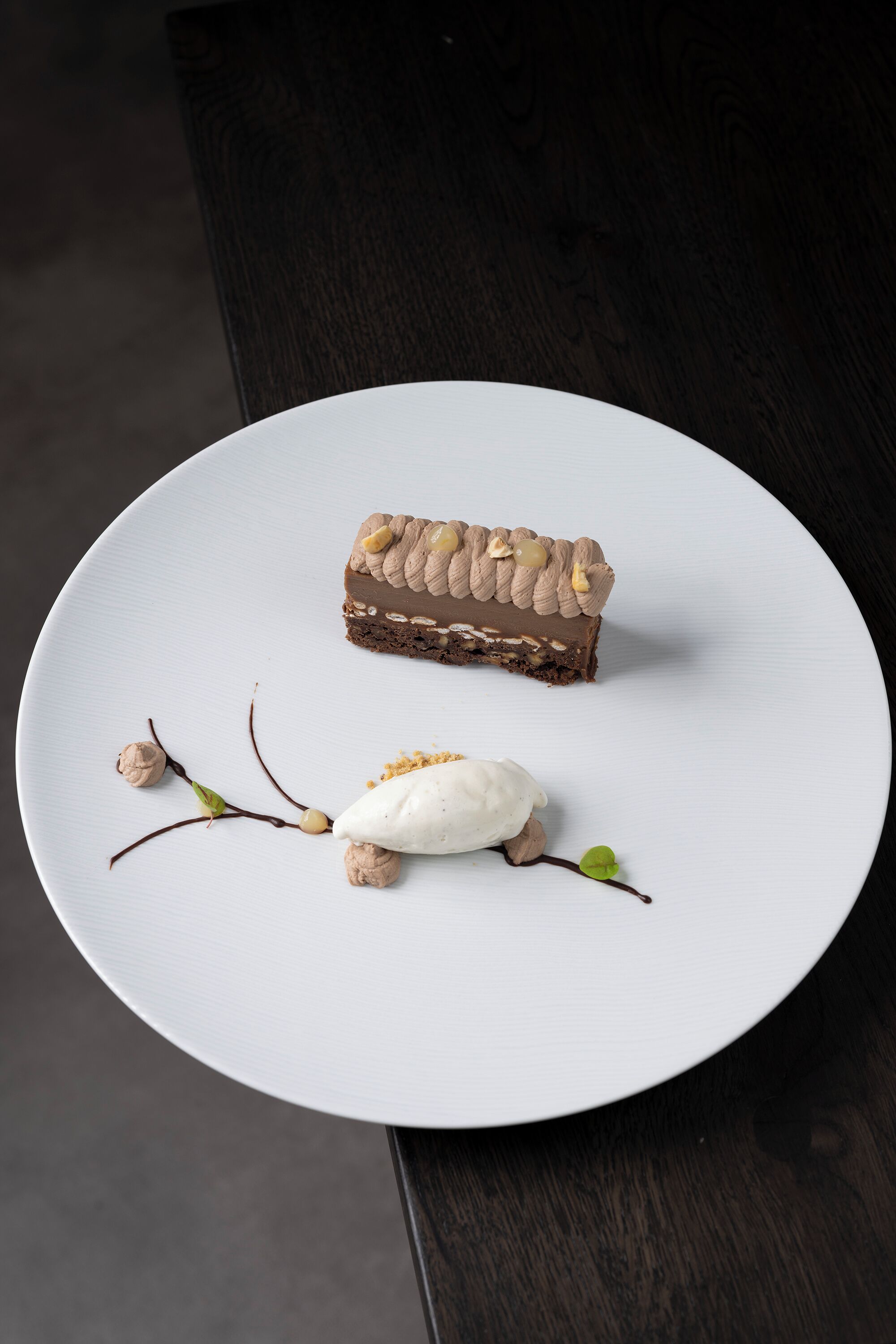A dessert on a white plate with a dark wooden table in the background.