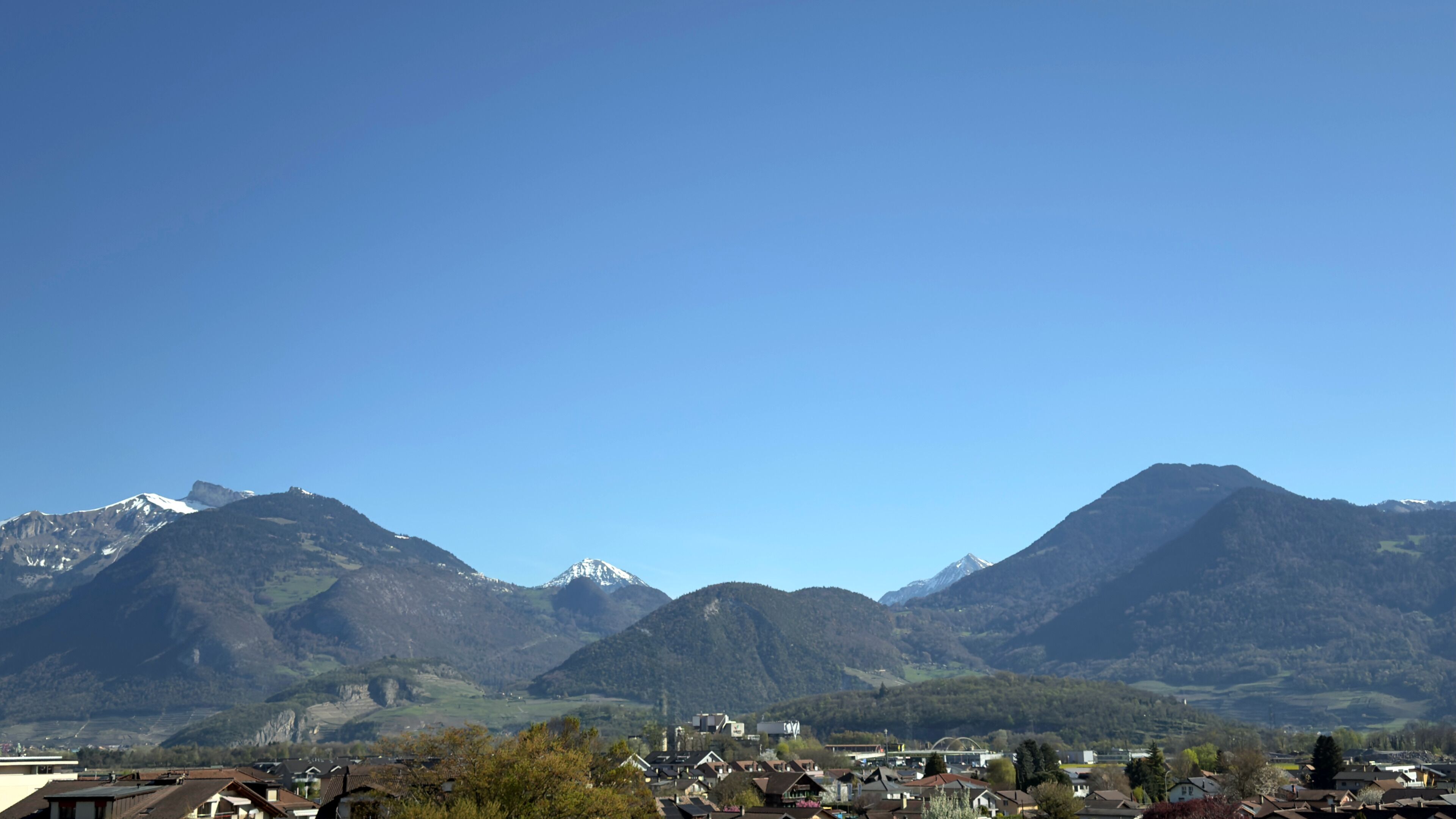A mountainous landscape with a town in the foreground.