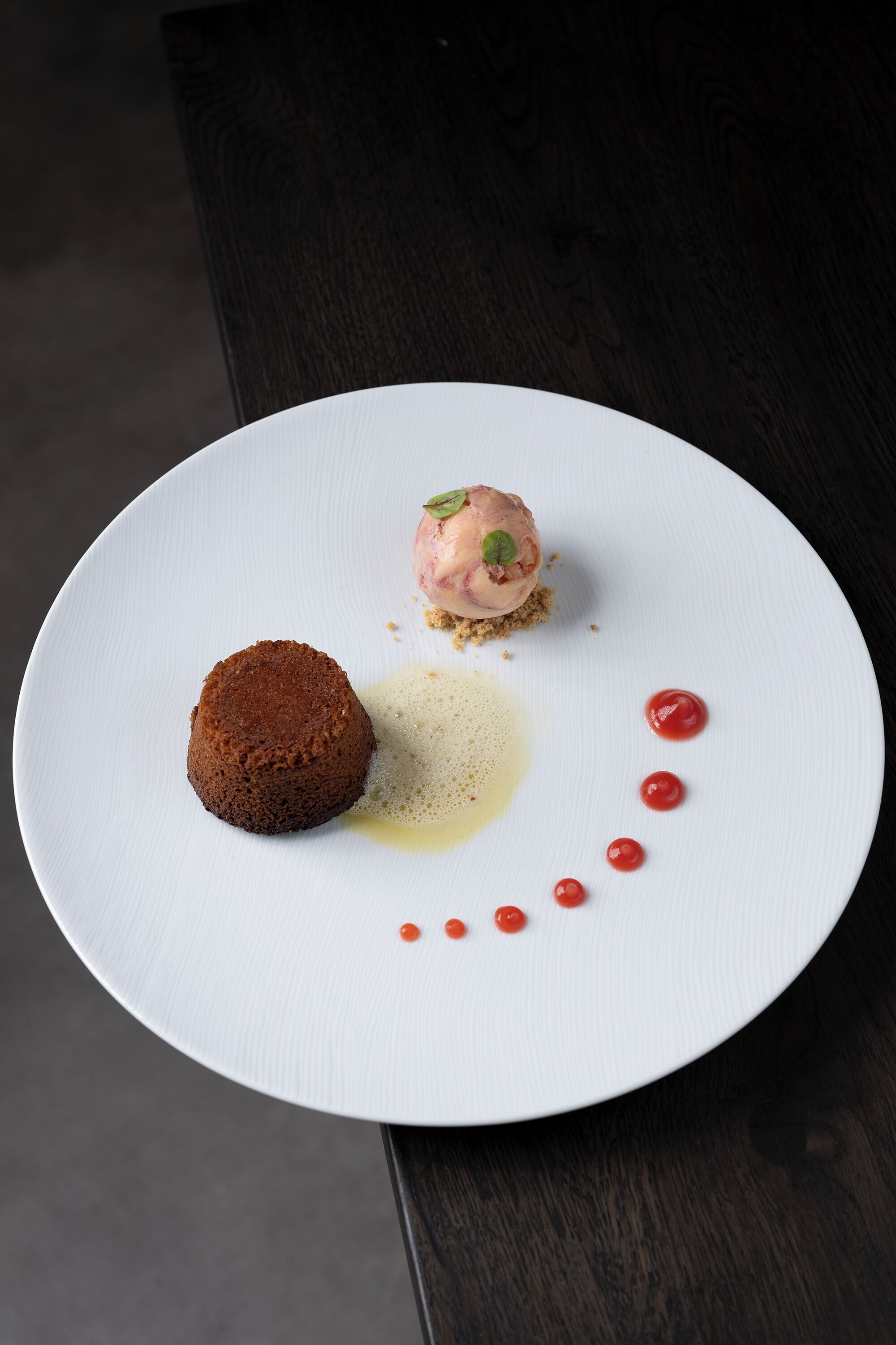 A dessert on a white plate with a dark background.