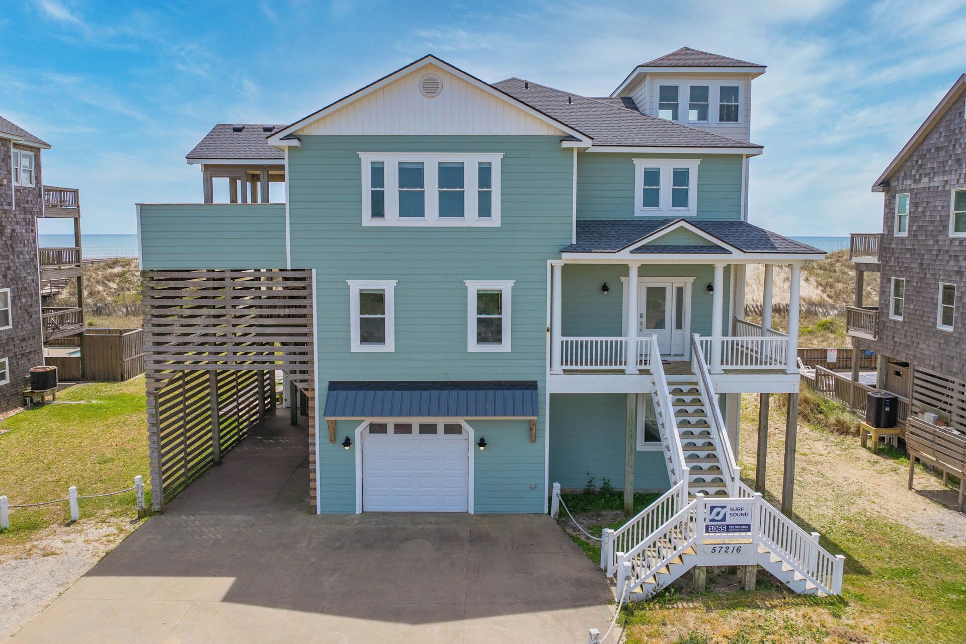 A two-story house with a front garage, a covered porch, and a staircase leading to a second-floor balcony.