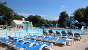 Un espace piscine avec des chaises longues et un toboggan.