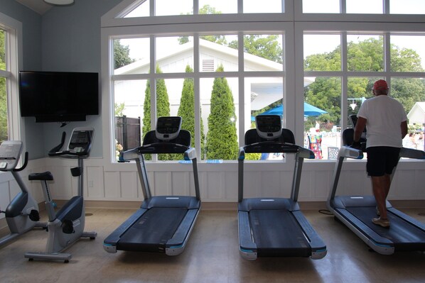 A gym with treadmills, a stationary bike, and a television.