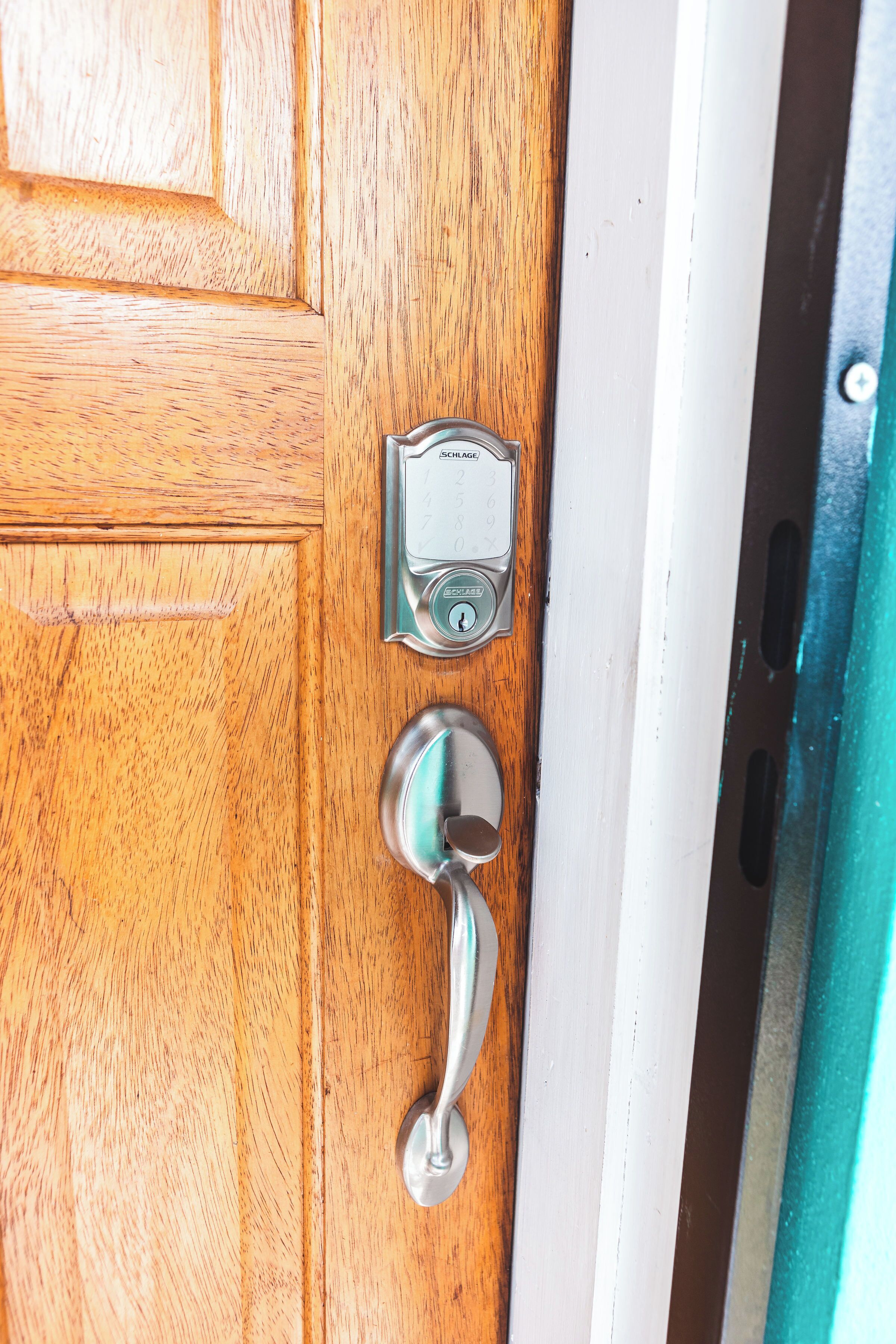 Une porte en bois équipée d’une sonnette et d’un clavier pour ouvrir la porte.