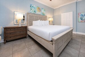 Une chambre à coucher avec un lit, des tables de chevet, une commode et des œuvres d’art accrochées aux murs.