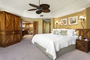 A bedroom with a large bed, wooden wardrobe, ceiling fan, and wall-mounted lamps. - Champion Ridge #35: Paradisiac Home w/Infinity Pool, Hot Tub & Tropical Feeling (Kamuela)