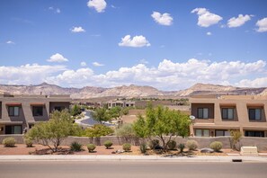A residential area with modern buildings, a clear sky, and mountains in the background. - A Green Escape at The Ledges (St. George)