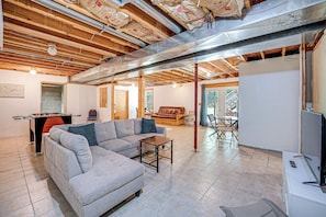 Relax in this spacious room with a large sofa, dining table, and foosball table.