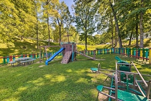 Children can play safely in this well-maintained outdoor play area with a slide, climbing frames, and swings.