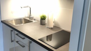 A modern kitchen with stainless steel appliances, a double sink, and a built-in oven.