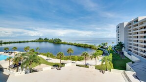 Ein Resort mit Pool, Palmen und Blick auf das Wasser.