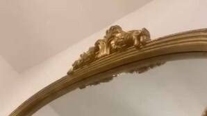 Un miroir encadré d’un cadre doré, orné de motifs complexes.