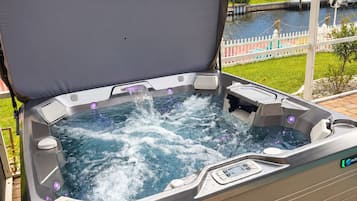 Un jacuzzi con vistas a un cuerpo de agua y palmeras.