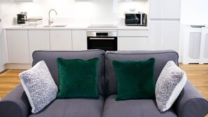 A modern kitchen with white cabinets, a microwave, and a coffee maker. - Guthrum Place 3bedroom Luxury Apt Royal Wharf Dock (London)