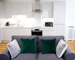 Relax in this stylish living space with a sofa, kitchen, and modern appliances.
