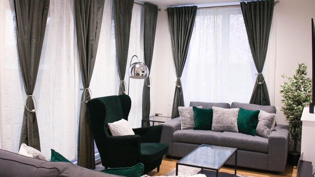 A modern living room with a sofa, armchair, and coffee table. - Guthrum Place 3bedroom Luxury Apt Royal Wharf Dock (London)