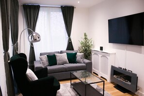 Relax in this stylish living room with a sofa, armchair, and flat-screen TV.