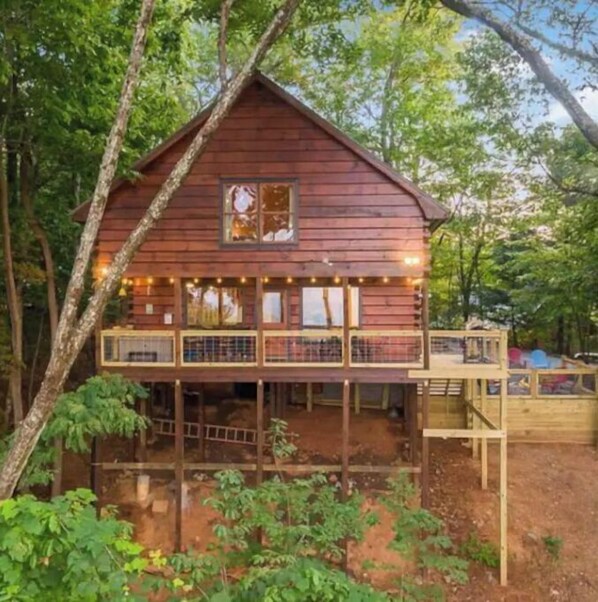 Escape to a serene cabin surrounded by lush greenery, with a balcony offering a peaceful retreat.