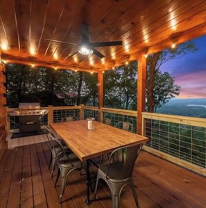 Relax on the deck with a scenic view, surrounded by a railing and equipped with a table and chairs.