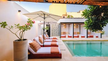 Una piscina al aire libre, cabañas de piscina gratuitas, sombrillas