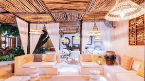 Un interior moderno con techo de madera, sofás blancos e iluminación colgante.