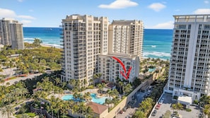 Un grand hôtel à plusieurs étages, doté d’une piscine et offrant une vue sur l’océan.