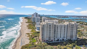 Un hôtel situé sur la côte, composé de plusieurs immeubles de grande hauteur, avec un accès direct à la plage et un port de plaisance.