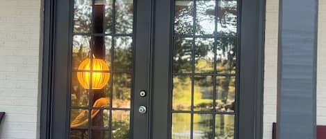 Enter a charming home through this inviting entrance, featuring a beautifully designed door and outdoor seating area.